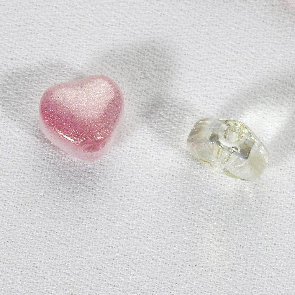20 transparent acrylic love heart beads in assorted colours on white background