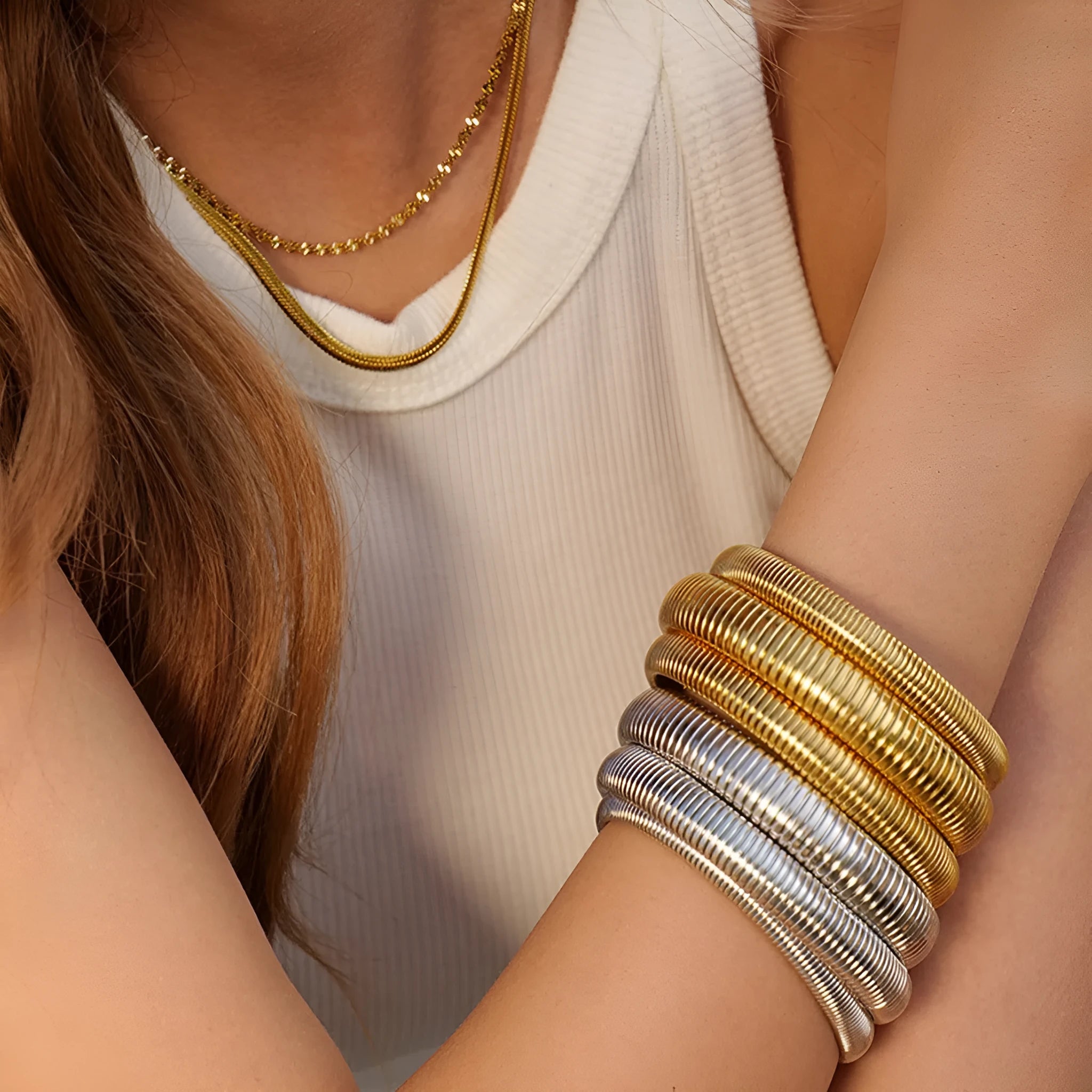 Gold titanium steel women's bracelet with elastic band and exaggerated vertical stripe ring pattern.
