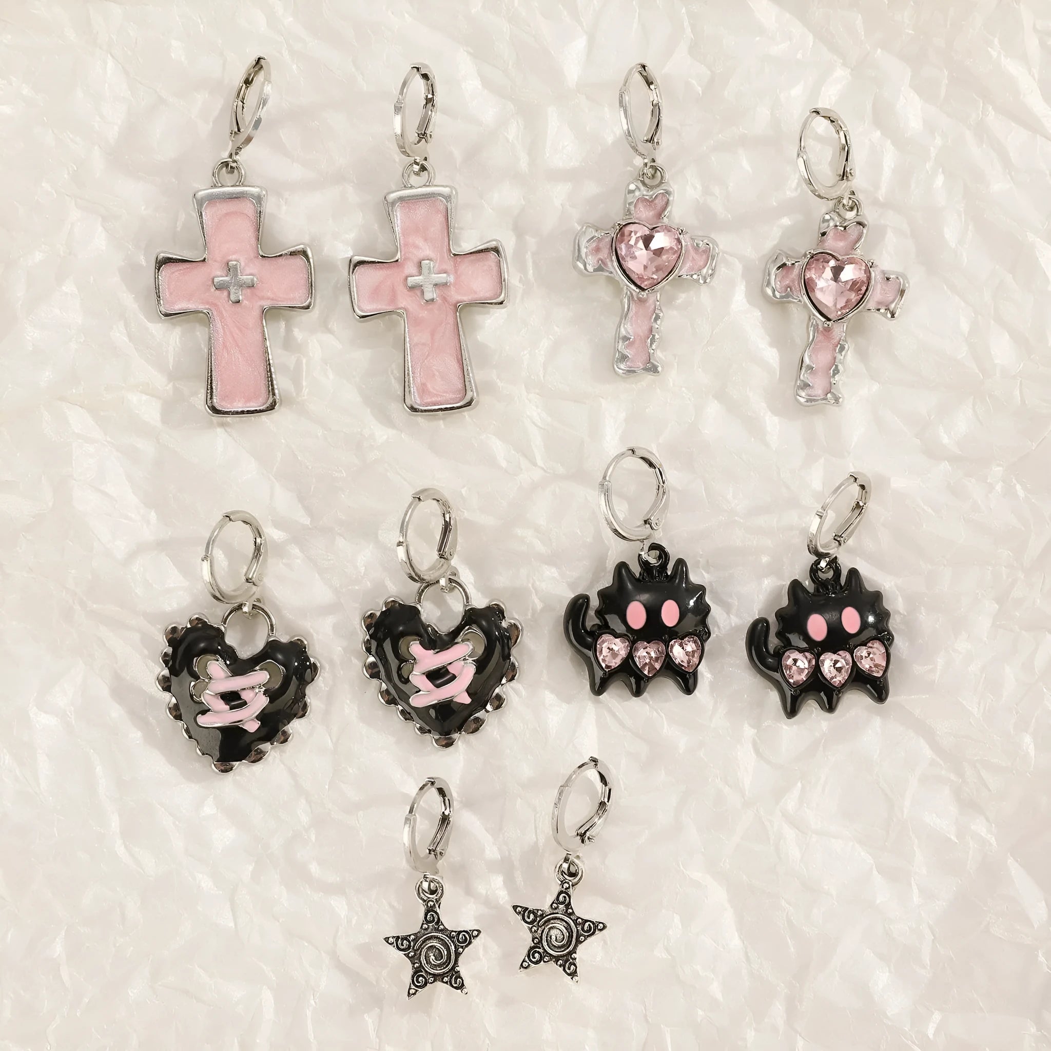 Women's alloy earrings with cross and character designs in five colour options including white cross and antique silver