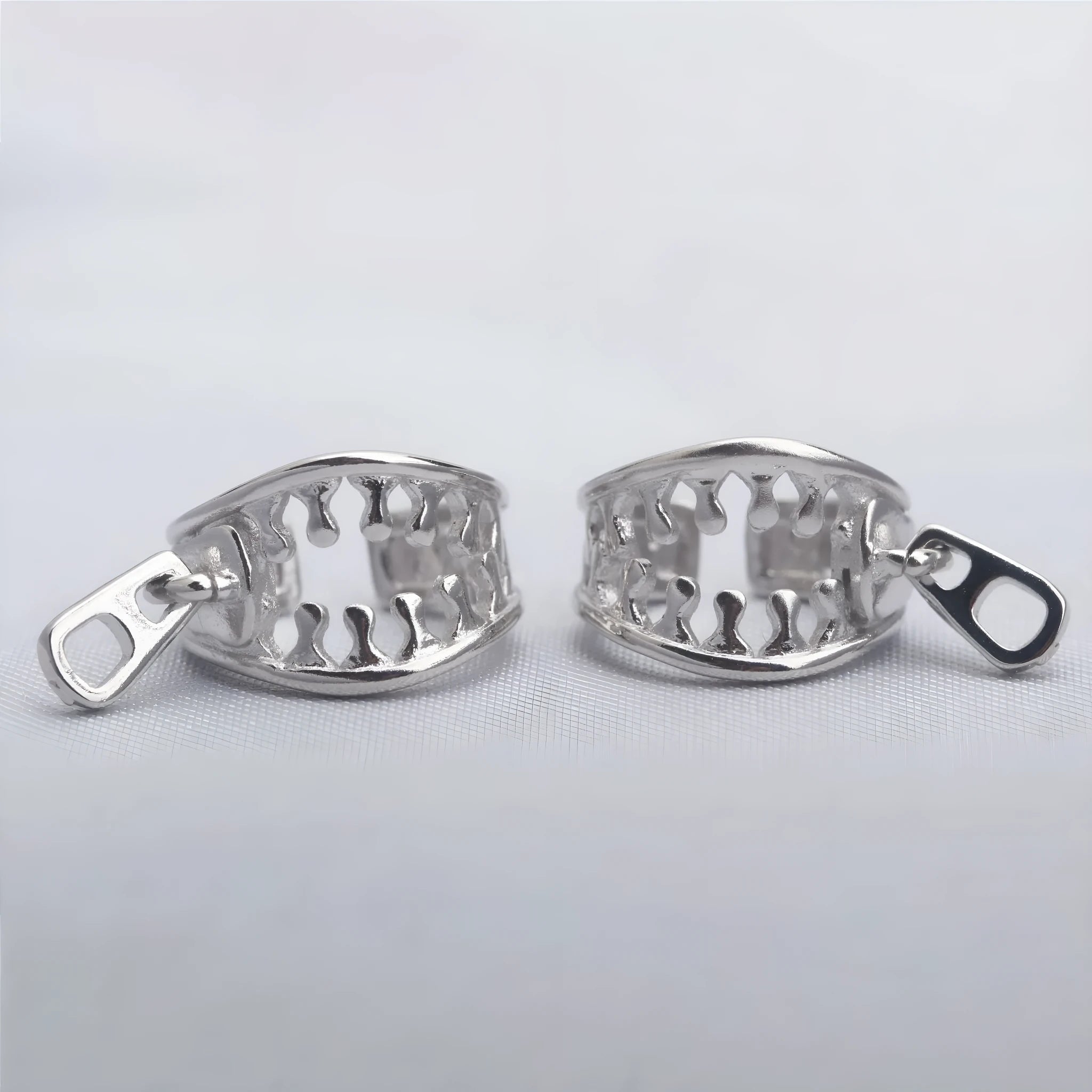 A pair of simple geometric copper ear clips with linear design and a zipper closure, colour ES862.