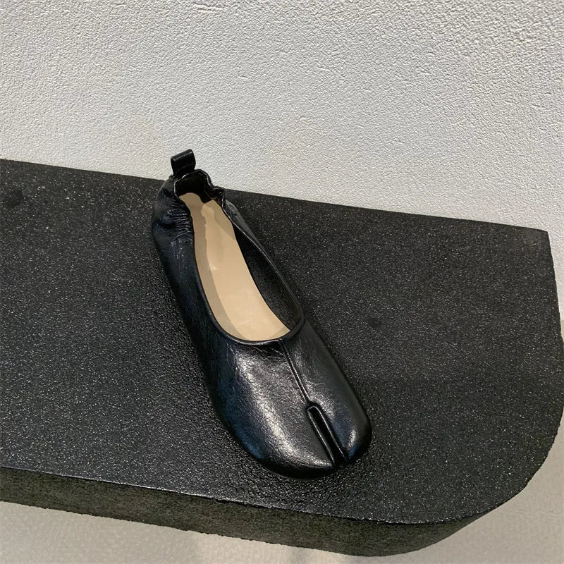 Women's black low heel pumps with chunky heel and round toe showing split toe horseshoe detail