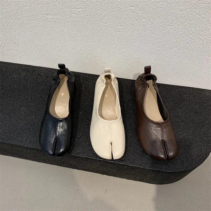 Women's black low heel pumps with chunky heel and round toe showing split toe horseshoe detail