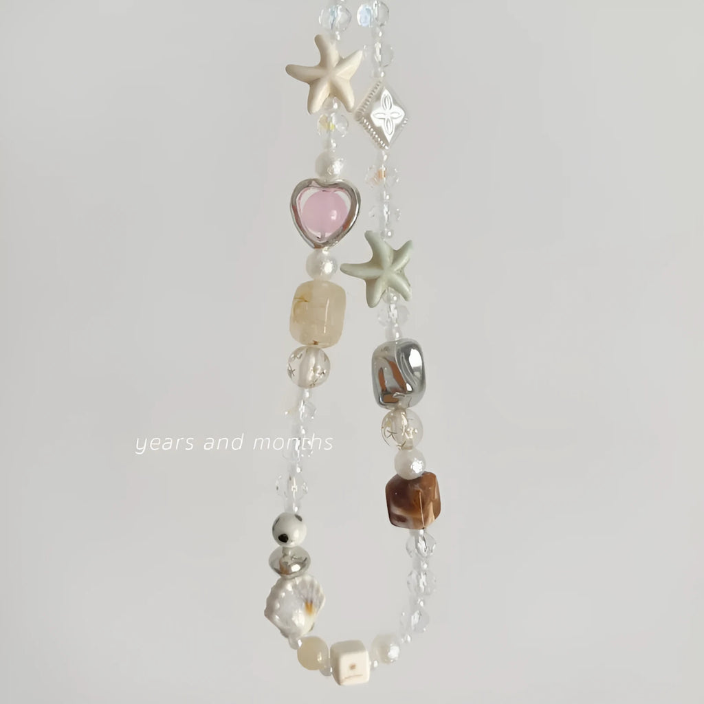Bohemian beaded mobile phone charm in Island Sweetheart colour with alloy chain and decorative beads on a plain background