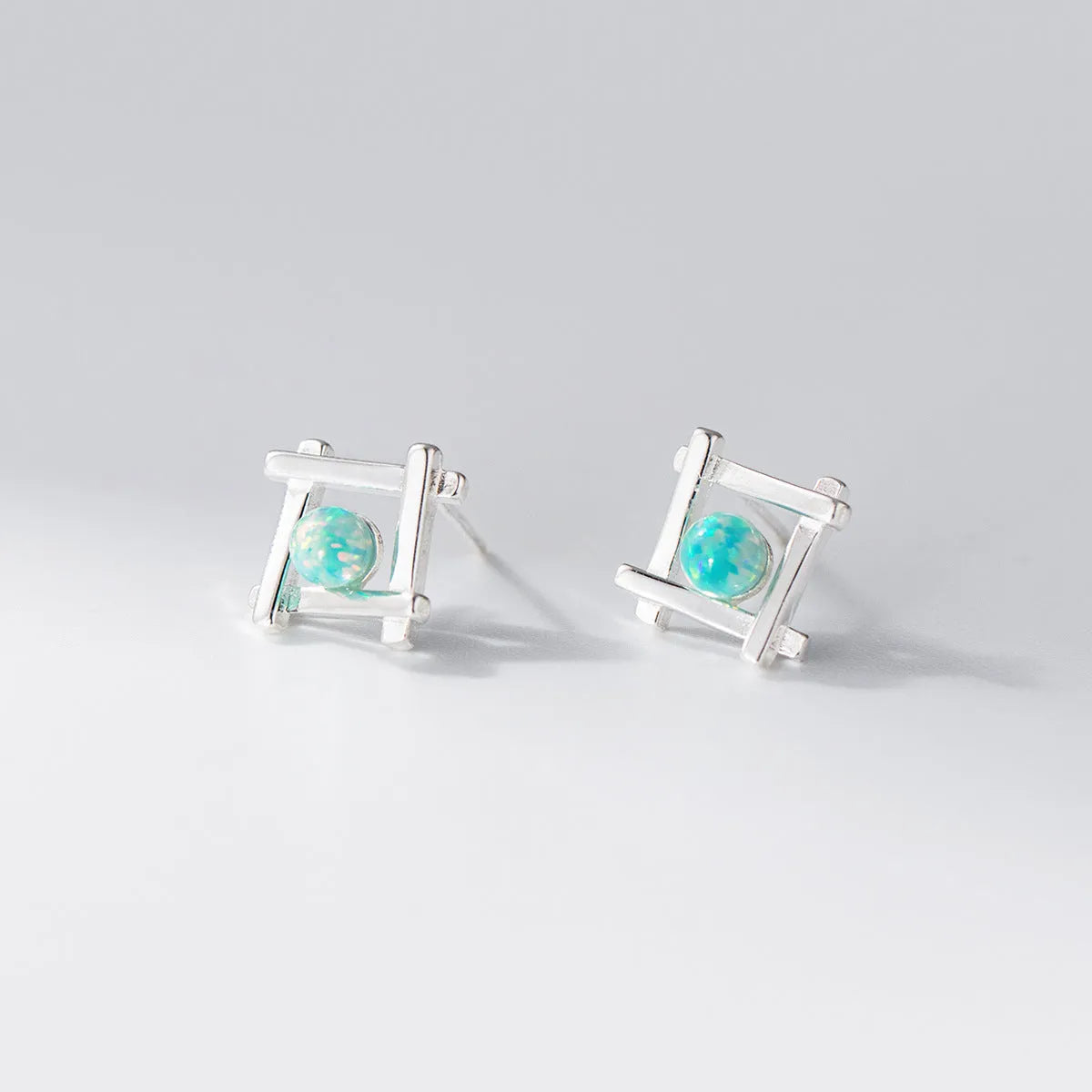 Geometric cross stud earrings in sterling silver with quadrangle shape and butterfly fastenings