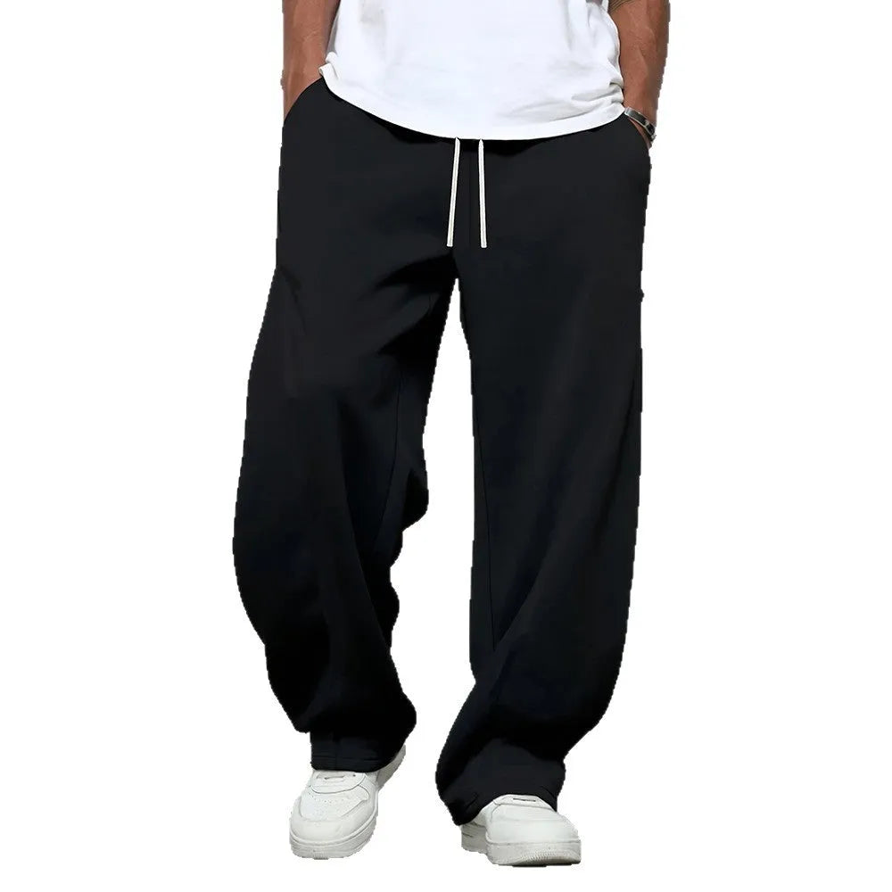 Man wearing solid grey straight-leg casual trousers with an elasticated waistband.