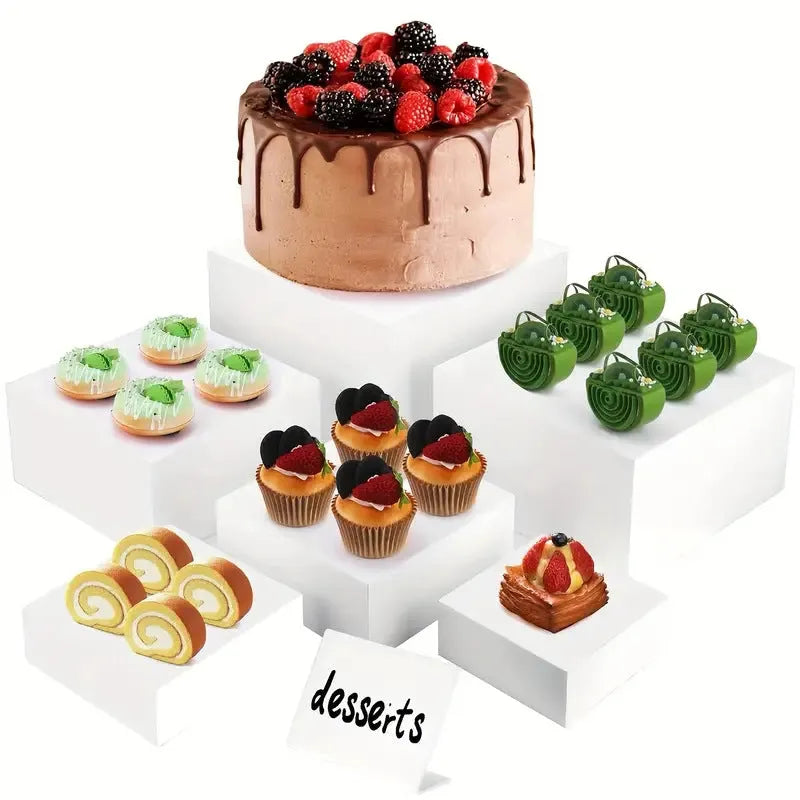 White plastic suit cube stacking dessert display stand with six pieces arranged for cake presentation.