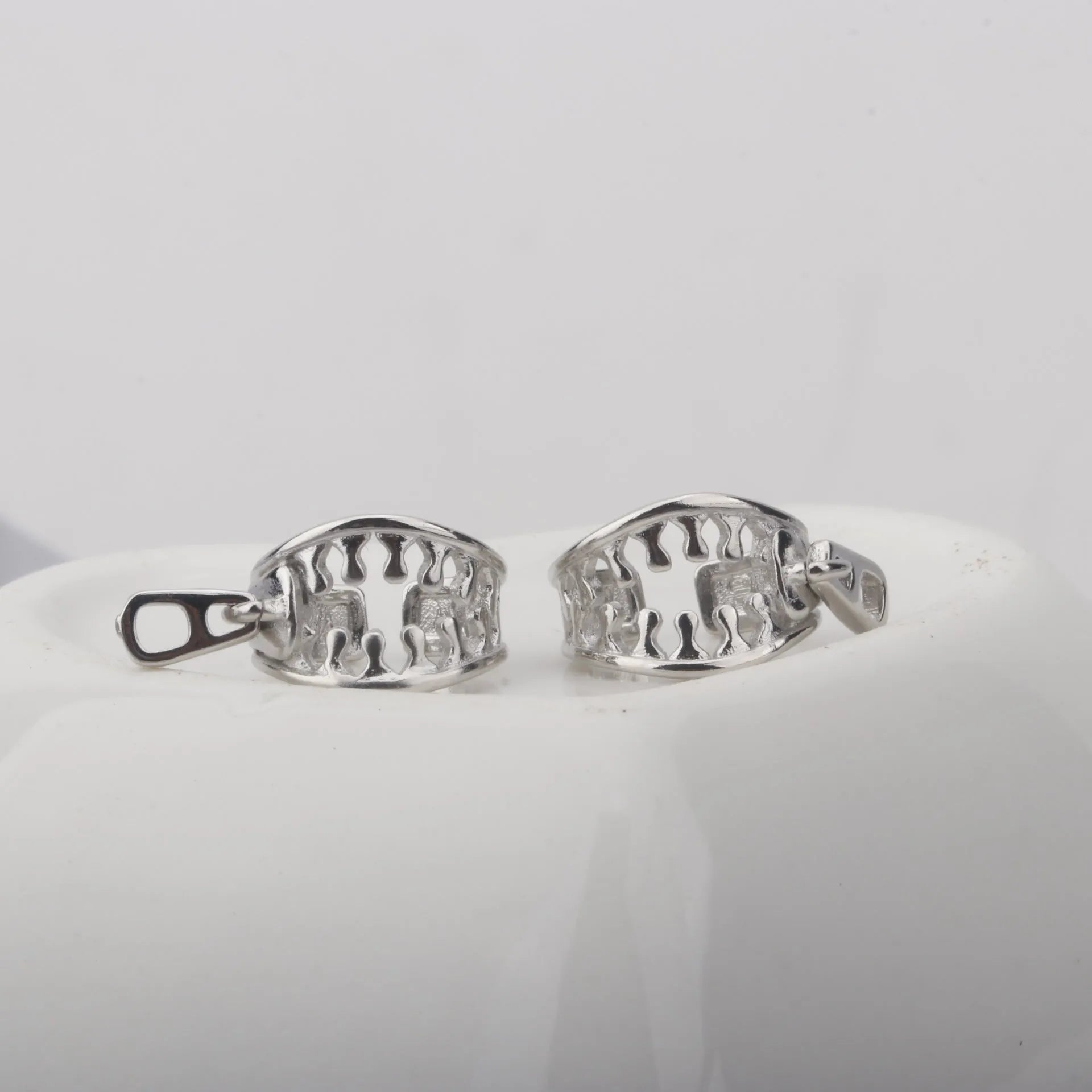 A pair of simple geometric copper ear clips with linear design and a zipper closure, colour ES862.