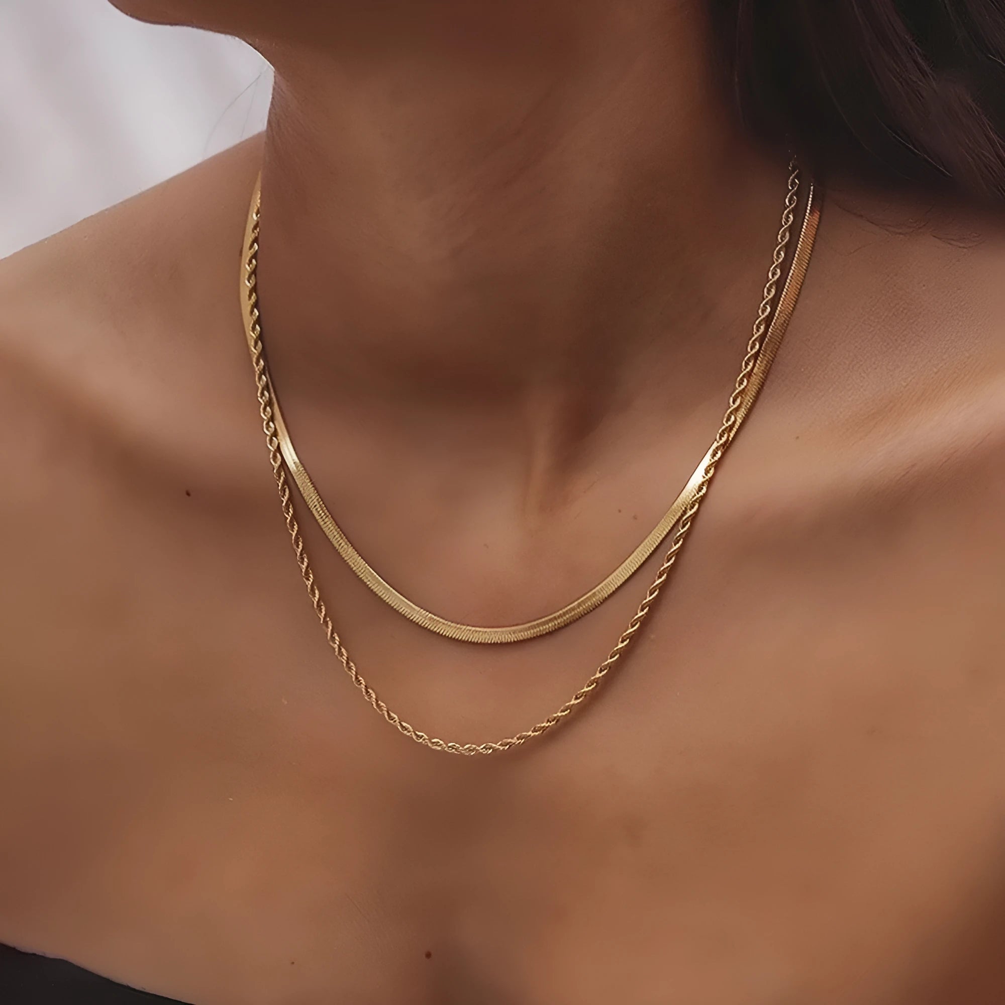 Geometric pendant necklace with snake bones chain in stainless steel, shown in a solid colour.