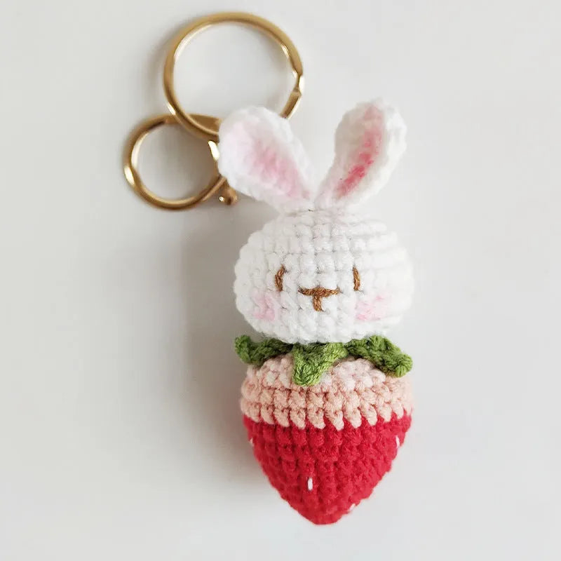 White hand-woven wire pendant in shape of a rabbit with a strawberry pattern, includes a key.