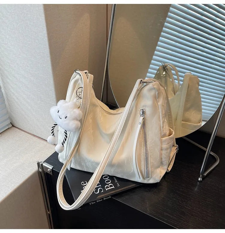 Soft PU women's fashion backpack in beige, shown with attached pendant accessory.
