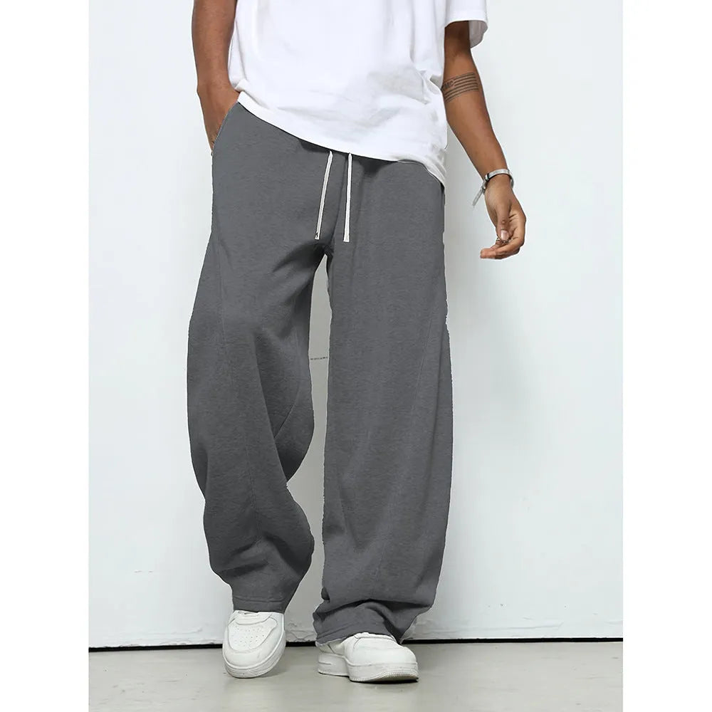 Man wearing solid grey straight-leg casual trousers with an elasticated waistband.