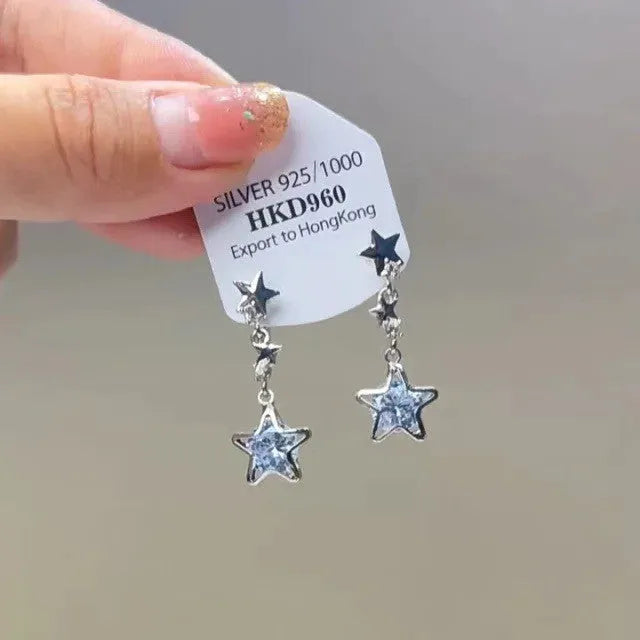 Close-up of women's geometric alloy earrings with rhinestones, a dangling tassel, and a heart detail.