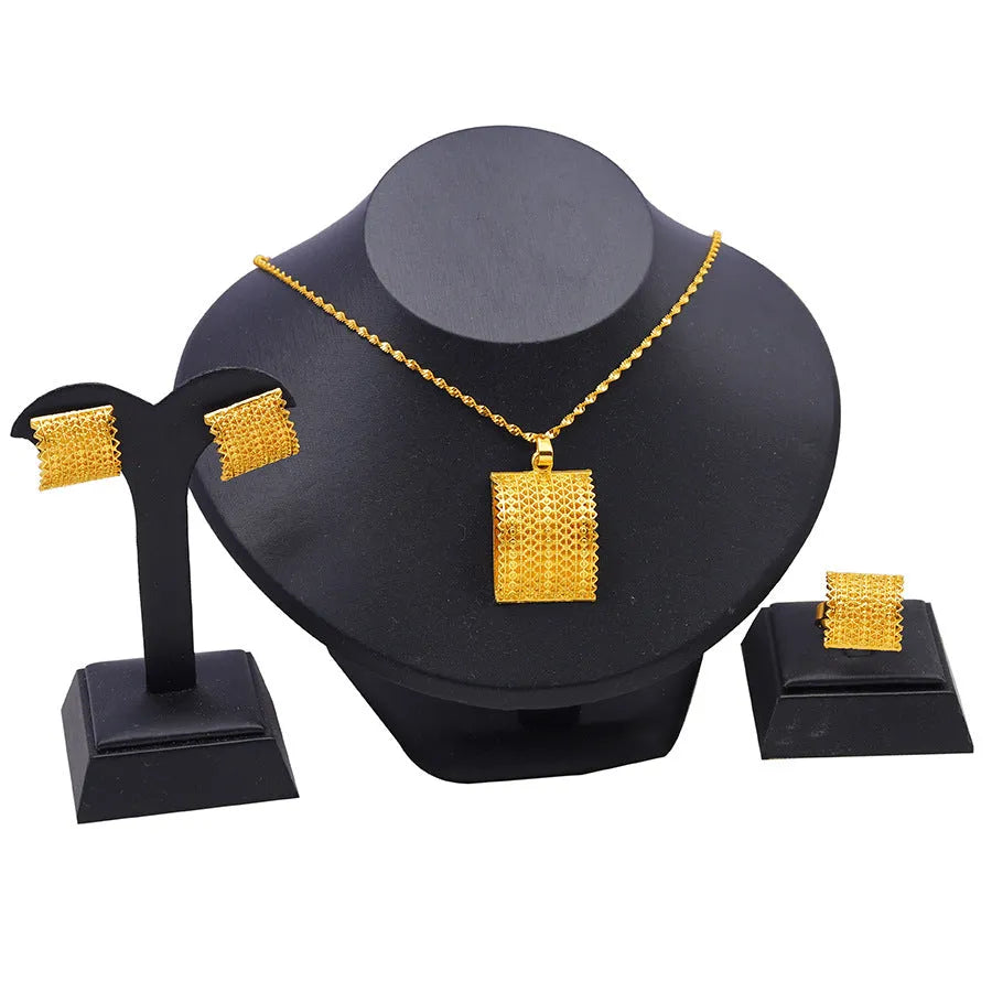Gold colour copper bridal jewellery set with necklace, earrings, and ring on display