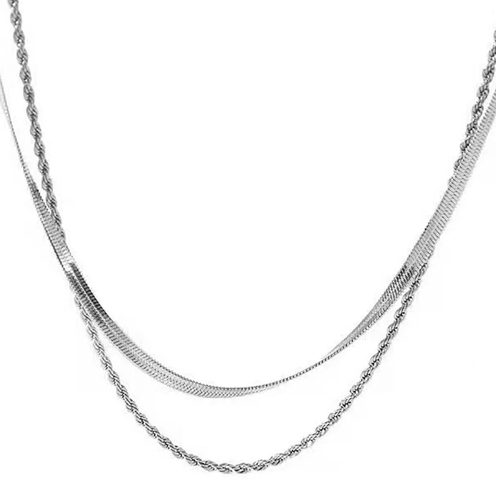 Geometric pendant necklace with snake bones chain in stainless steel, shown in a solid colour.