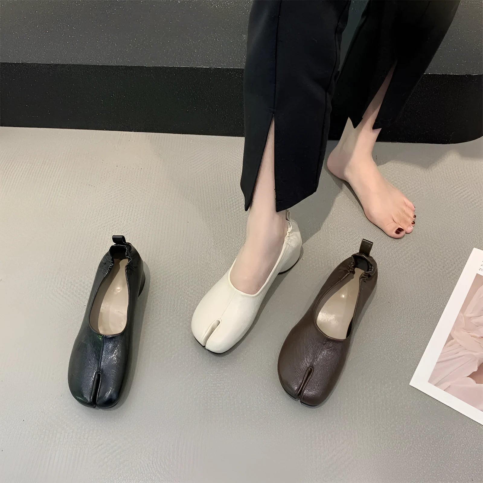 Women's black low heel pumps with chunky heel and round toe showing split toe horseshoe detail