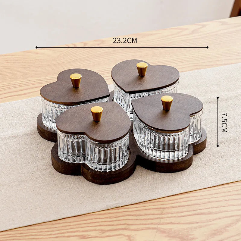 Glass foot bath fruit platter with coloured glaze and transparent heart-shaped lids on a multi-grid snack tray.