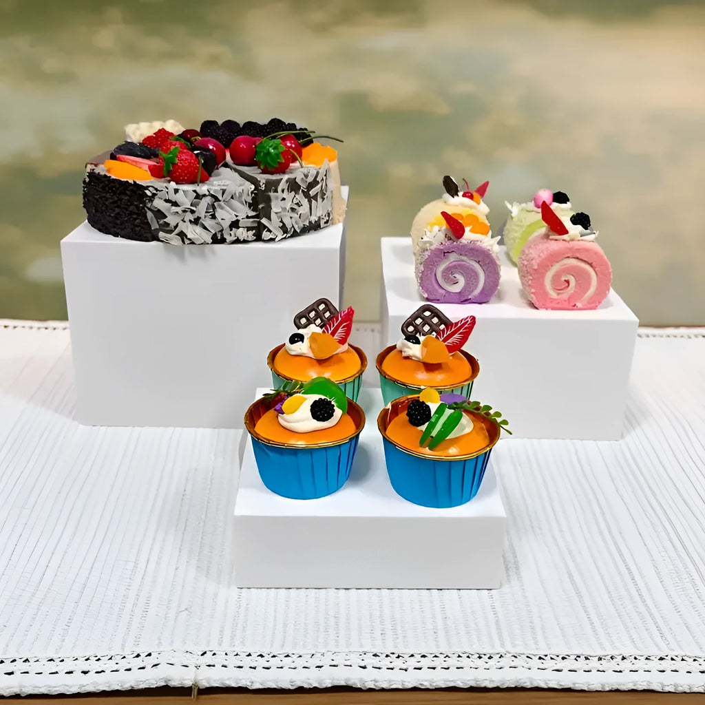 White plastic suit cube stacking dessert display stand with six pieces arranged for cake presentation.