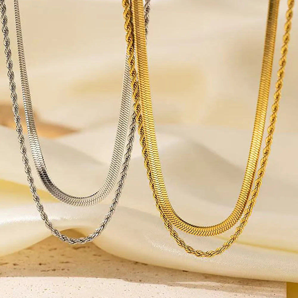 Geometric pendant necklace with snake bones chain in stainless steel, shown in a solid colour.