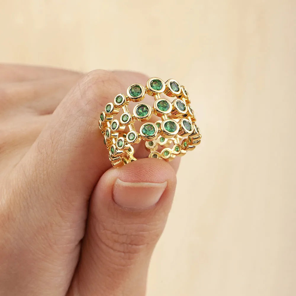 Gold coloured wide band ring with three layers of green zircons on a copper base plated with 18K real gold.