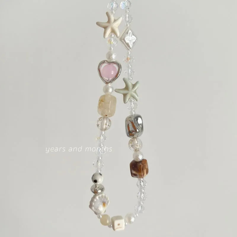 Bohemian beaded mobile phone charm in Island Sweetheart colour with alloy chain and decorative beads on a plain background
