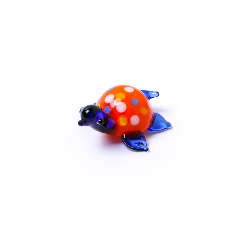 Geometric glass turtle ornament in a modern style displayed on a wooden surface.