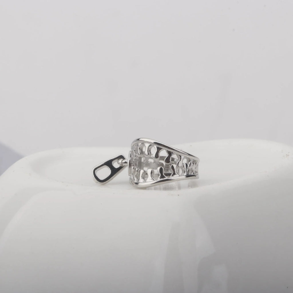 A pair of simple geometric copper ear clips with linear design and a zipper closure, colour ES862.