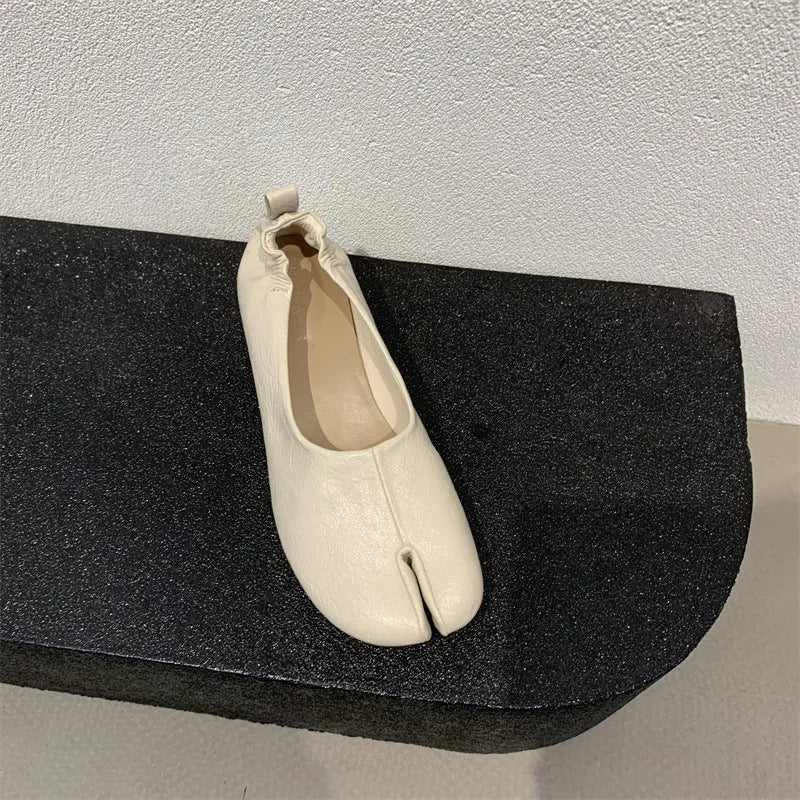Women's black low heel pumps with chunky heel and round toe showing split toe horseshoe detail