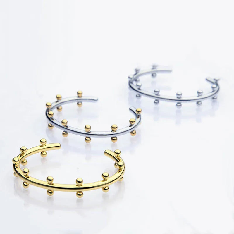 Adjustable C-shaped bracelet with round stainless steel bean beads on an alloy chain.