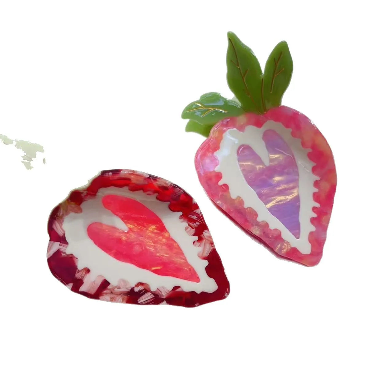 Close-up of a handmade strawberry hair clip in red or pink on a white background.