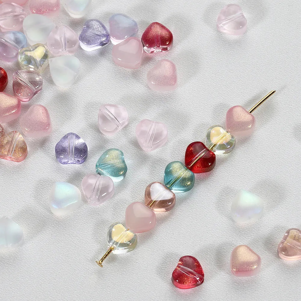20 transparent acrylic love heart beads in assorted colours on white background