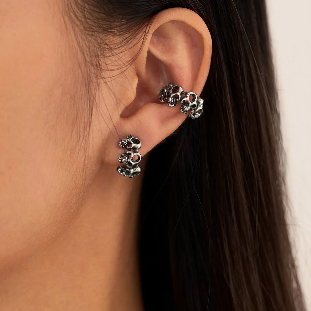 Geometric hollow skull ear clips in stainless steel with electroplated finish