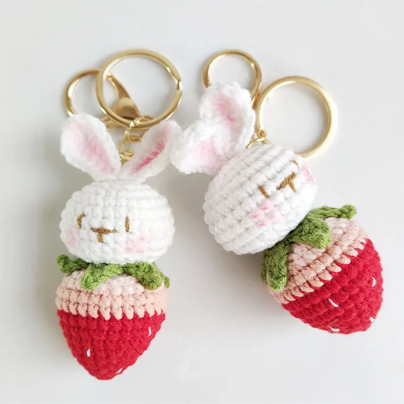 White hand-woven wire pendant in shape of a rabbit with a strawberry pattern, includes a key.