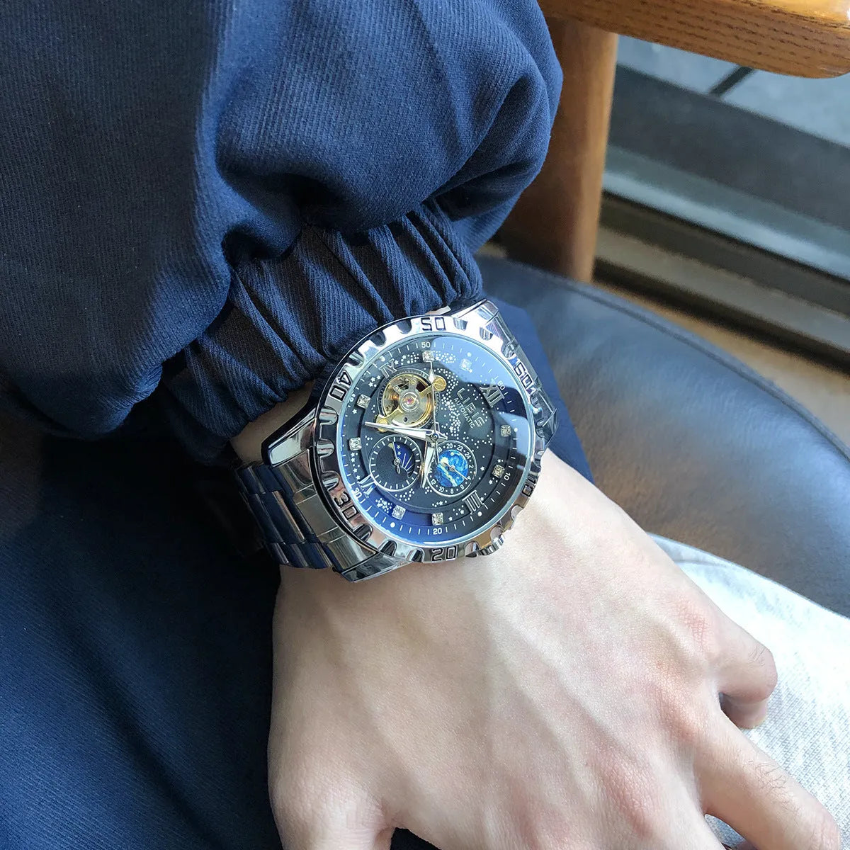 Men's silver case automatic watch with black dial, luminous hands and transparent mechanical case back