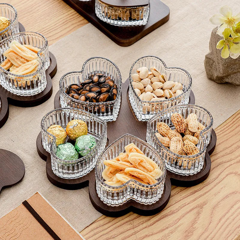 Glass foot bath fruit platter with coloured glaze and transparent heart-shaped lids on a multi-grid snack tray.
