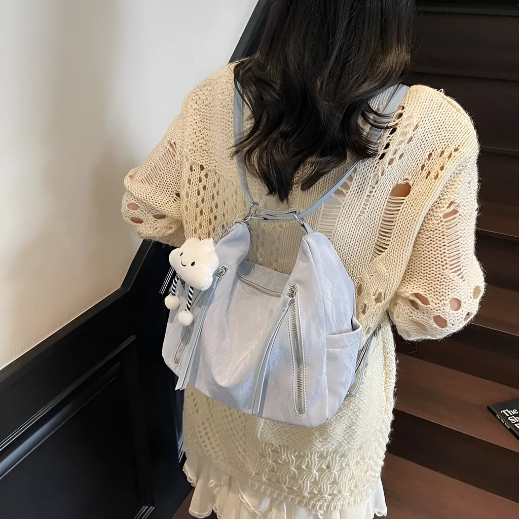Soft PU women's fashion backpack in beige, shown with attached pendant accessory.