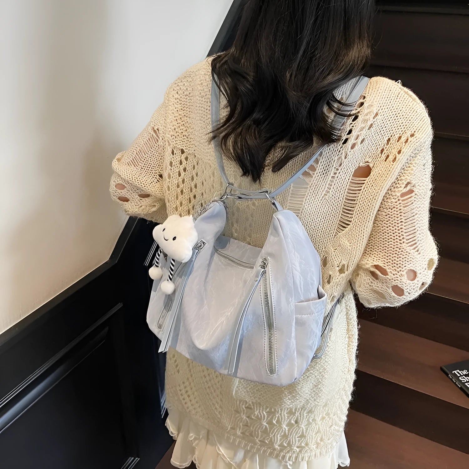 Soft PU women's fashion backpack in beige, shown with attached pendant accessory.