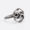 Steel-coloured titanium steel ring with a detailed double snake design on a grey background.