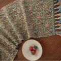 Nordic jacquard bouquet pattern table runner with tassels in dark blue on wooden table