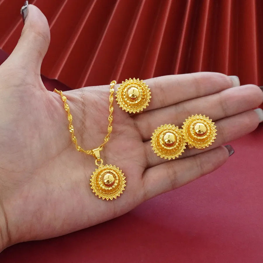 Three-piece gold-plated jewellery set with floral design including pendant necklace, earrings and ring