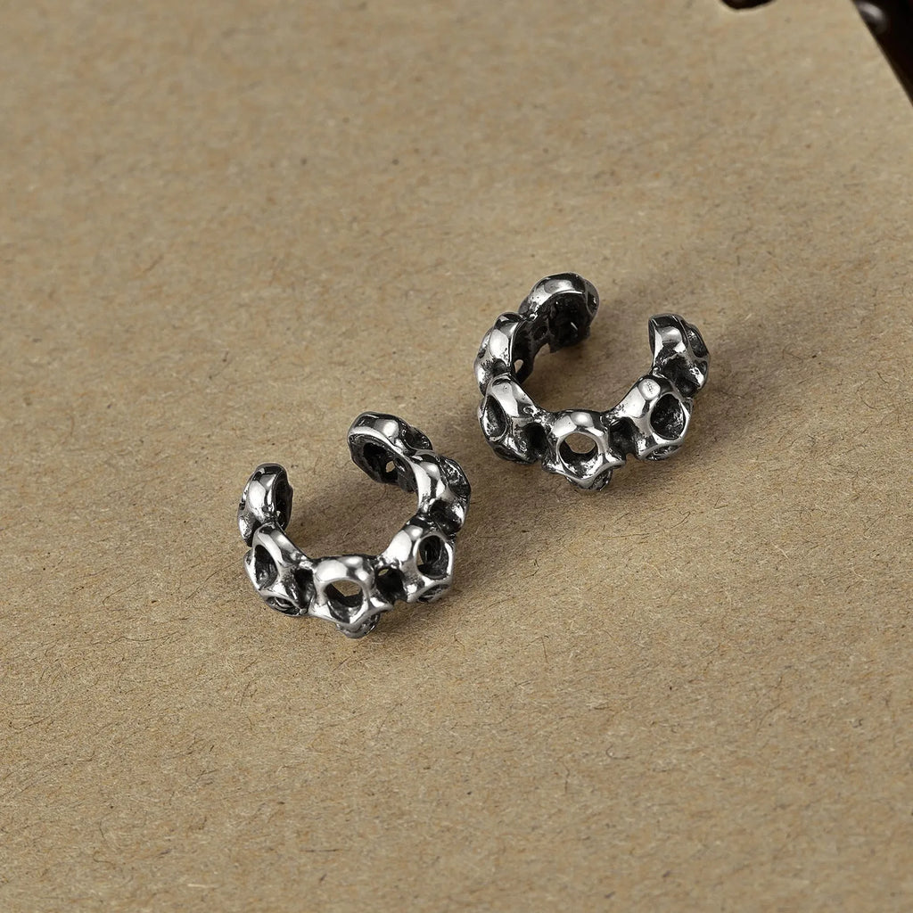 Geometric hollow skull ear clips in stainless steel with electroplated finish