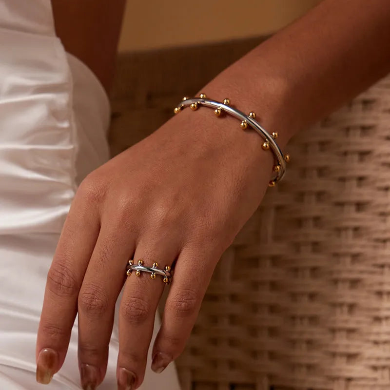 Adjustable C-shaped bracelet with round stainless steel bean beads on an alloy chain.