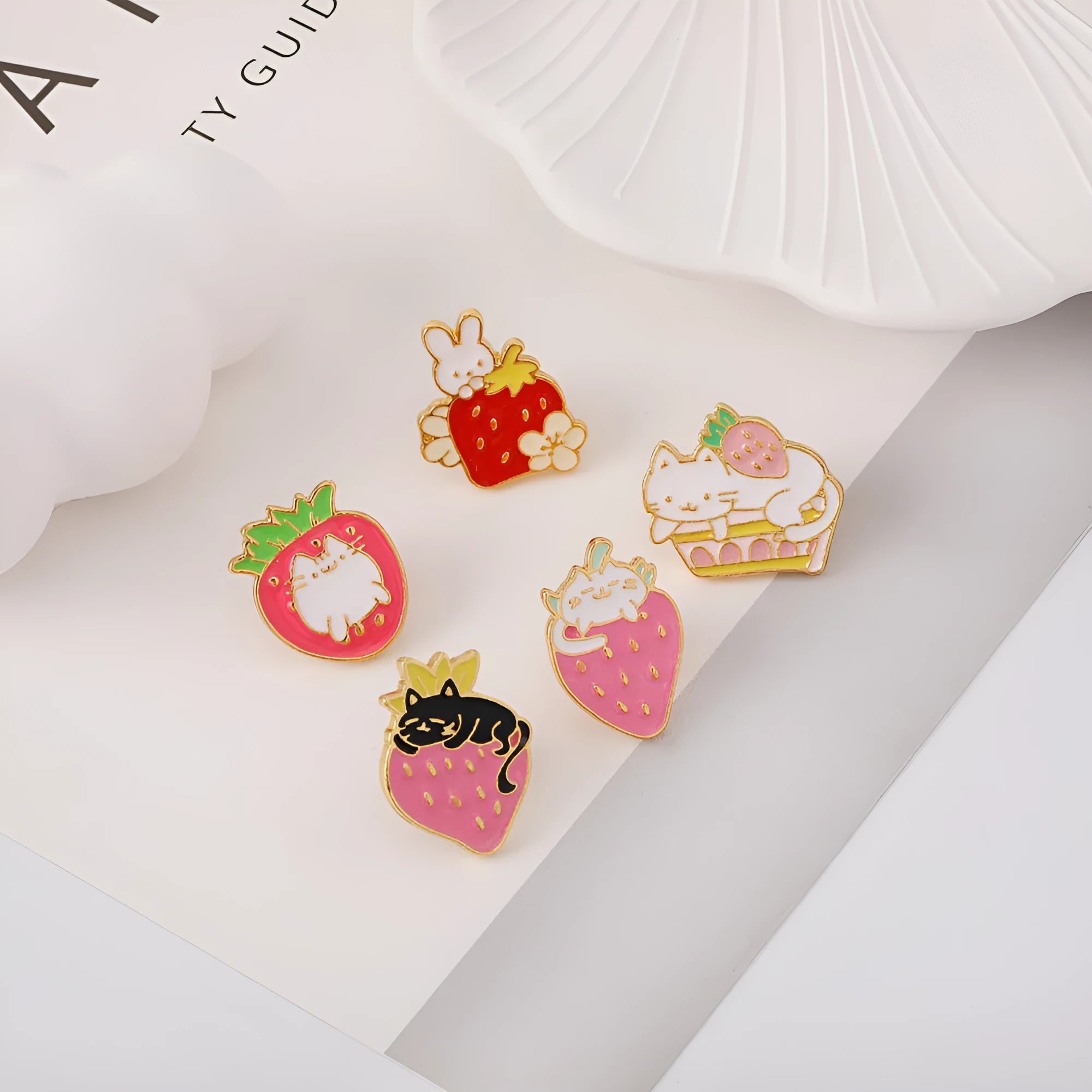 Cat strawberry metal brooch with alloy finish in five colour options on a bag