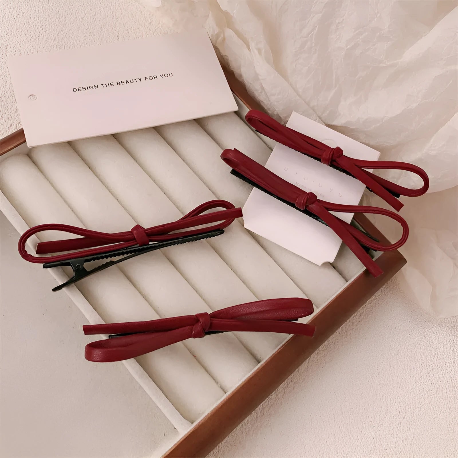 Wine red leather bow hair barrettes for women, showing front and side views