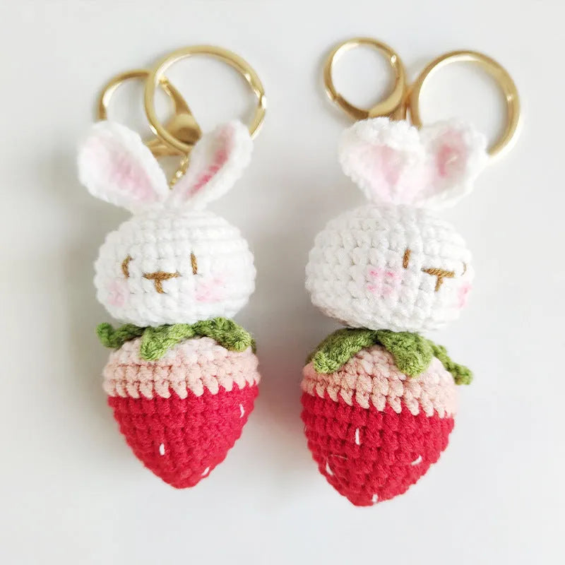 White hand-woven wire pendant in shape of a rabbit with a strawberry pattern, includes a key.