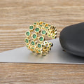 Gold coloured wide band ring with three layers of green zircons on a copper base plated with 18K real gold.