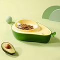Avocado-shaped automatic water pet feeder with a green water reservoir and a pink slow food bowl on a white surface