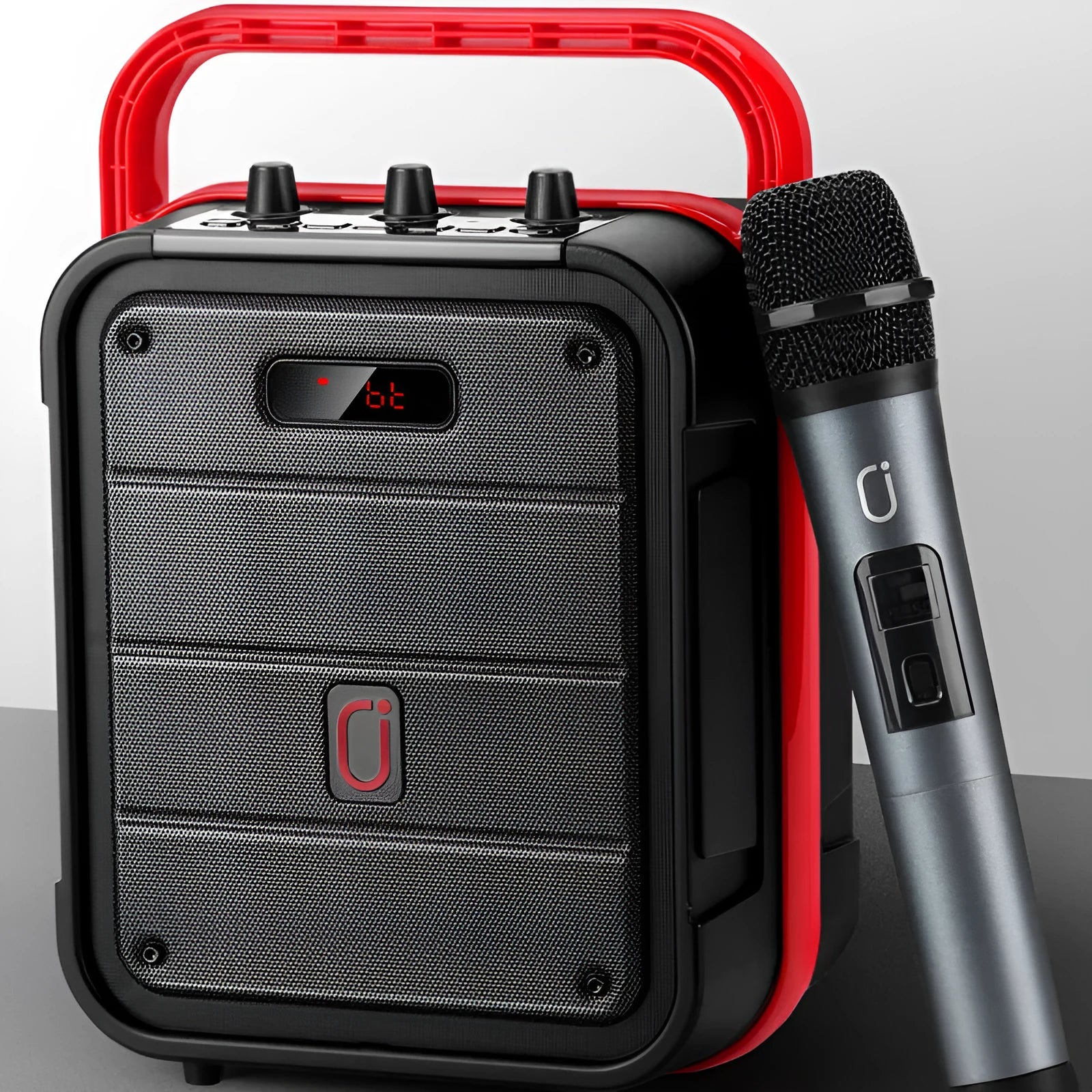 MS62AI portable Bluetooth speaker with wireless microphone on a table, showing remote control and charging cable.