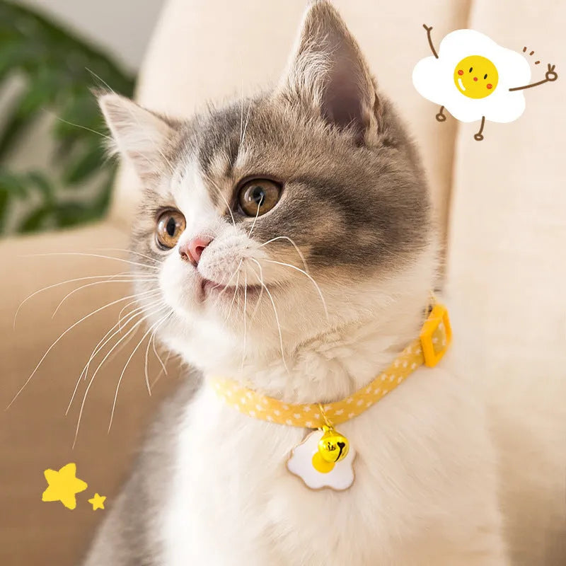 Green adjustable cat collar with a metal bell and red bow tie on a white background.