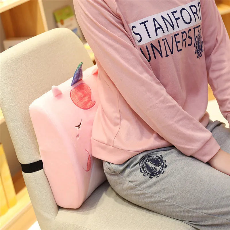 Cartoon character lumbar support pillow with removable memory foam core in pink unicorn design on office chair.