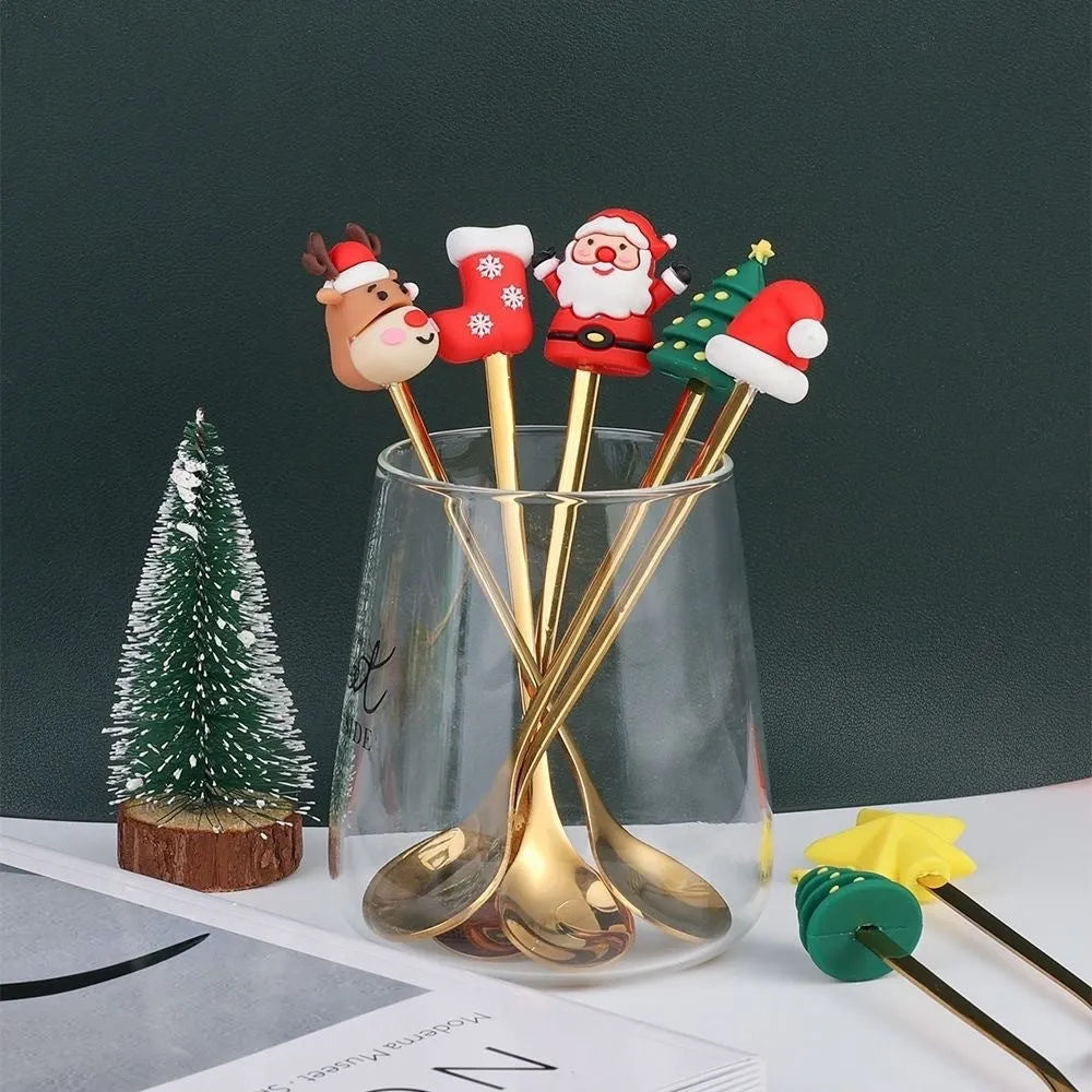 Four stainless steel Christmas spoons and forks with red handles showing Christmas tree and snowman designs on a white background